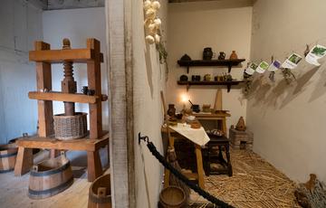 Two small rooms storing a wooden machine and bottles.