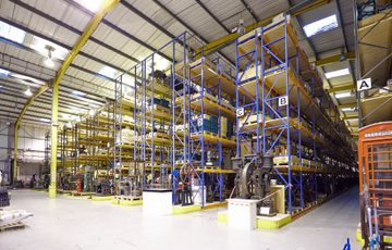 A large warehouse of artefacts on racking that goes to the ceiling.
