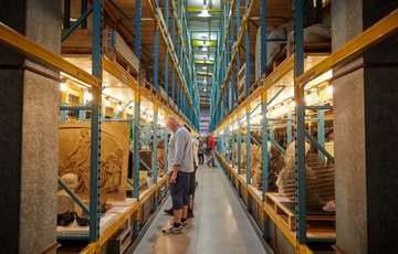 Racks in a large storage area containing stone sculptures