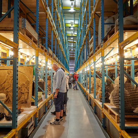 Racks in a large storage area containing stone sculptures