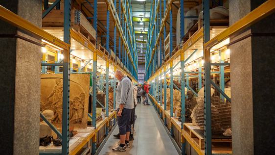 Racks in a large storage area containing stone sculptures