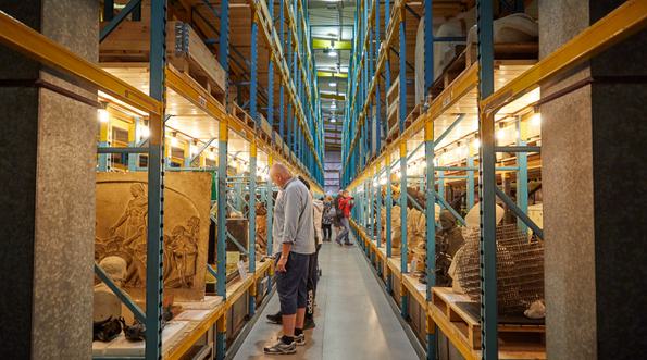 Racks in a large storage area containing stone sculptures