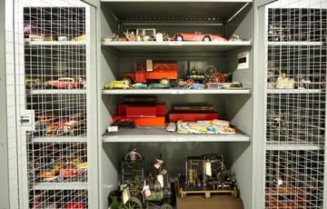Storage cage containing vintage metal toy cars and trains