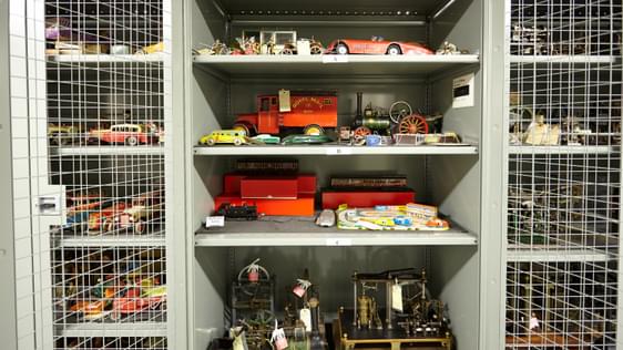 Storage cage containing vintage metal toy cars and trains