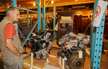 A person looking at an engine on display.