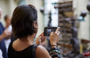 A person from behind taking a photo of machinery.