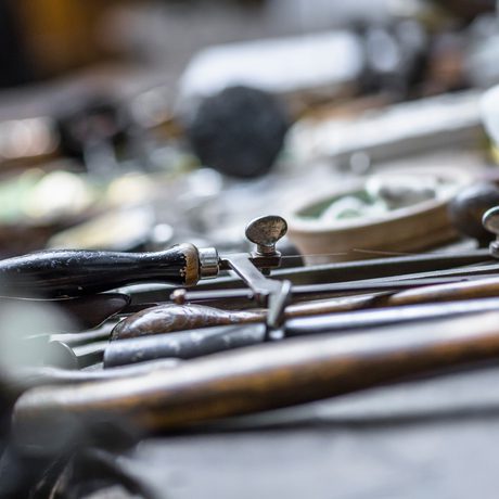 Close up of jewellery maker tools laid out on a workbench.