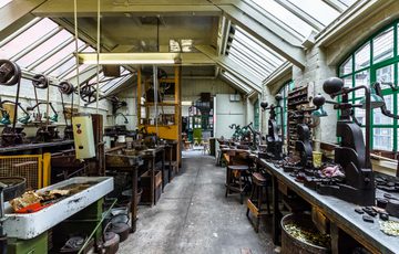 Industrial workshop with glass roof containing metal turning machinery and metal presses