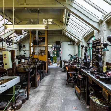 Industrial workshop with glass roof containing metal turning machinery and metal presses
