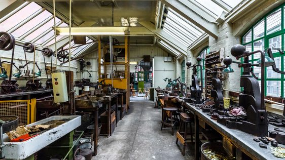 Industrial workshop with glass roof containing metal turning machinery and metal presses