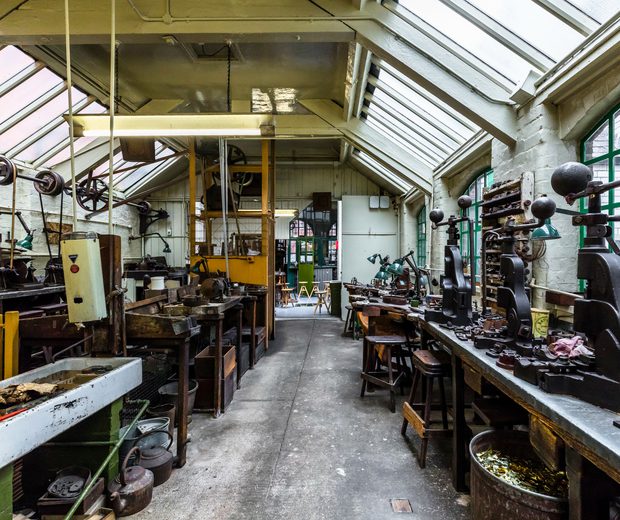 Industrial workshop with glass roof containing metal turning machinery and metal presses