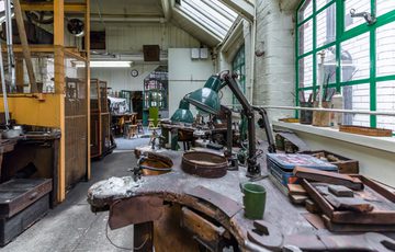 A jewellery work bench with lamps and tools in a jewellery workshop.