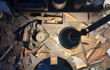 Overhead shot of workbench of tools lit with a lamp.