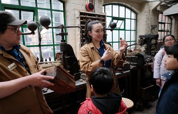 Two staff members showing items to a small group of children.