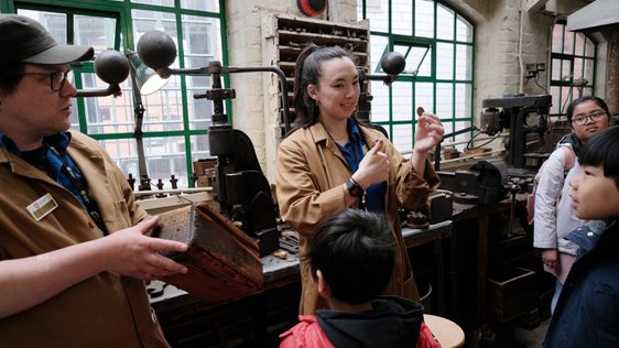 Two staff members showing items to a small group of children.