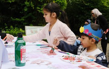 Two children painting at a craft table.