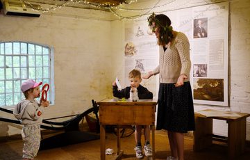 An adult and two child inside the mill.
