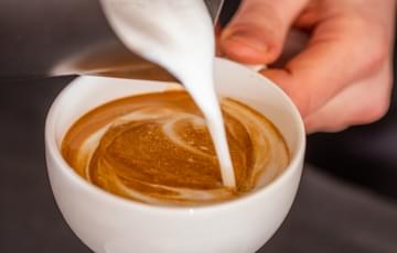 Milk being poured into a coffee cup.