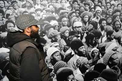 A person standing looking at large photograph on the wall.