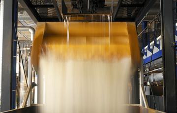 Close up of water pouring from the top of a steam engine into a bucket then into a hopper at the bottom