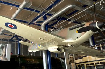 A Fighter Aircraft on display suspended from the ceiling, the view is from below.