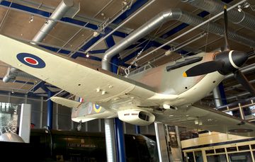 A Fighter Aircraft on display suspended from the ceiling, the view is from below.