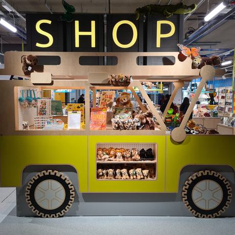 A wooden jeep that is full of cuddly animal toys for sale.