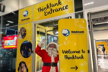 Santa at the entrance to Thinktank with sign that reads 'Welcome to Thinktank'.