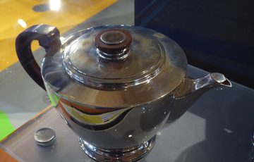 A silver teapot on display.