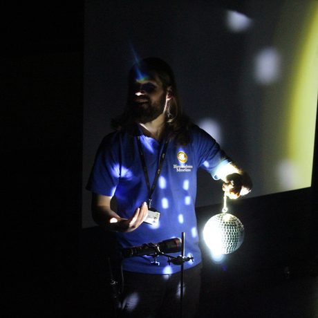 Staff member holding a disco ball.
