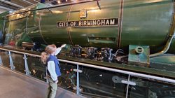 A child pointing to the City of Birmingham train on display.