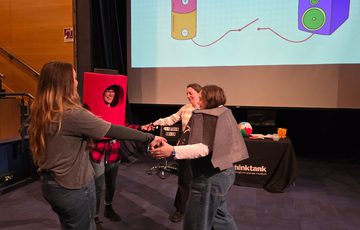 A group of staff dress as a battery and speaker performing a science show.