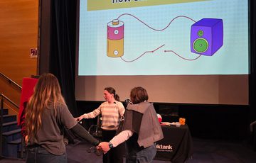 A group of staff dress as a battery and speaker performing a science show.