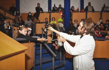 A Thinktank Learning Officer interacting with a child during a family show in the theatre.