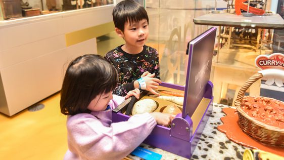Two children playing with an interactive box.