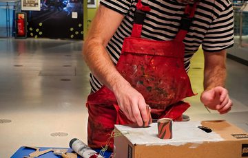 A person creating a cardboard box sculpture.