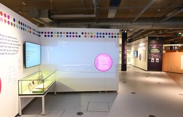 A screen, projection and display case from the exhibition.