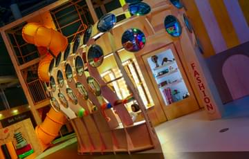A child's play building in MiniBrum constructed of mirrored circles with fashion and salon items inside.