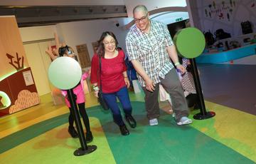 Two adults racing on the play race track.