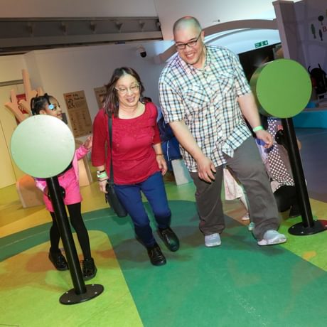 Two adults racing on the play race track.