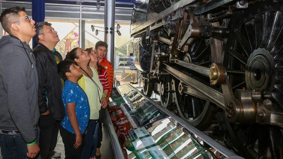 A family looking up at steam train.