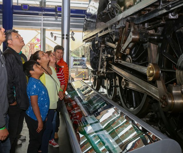 A family looking up at steam train.