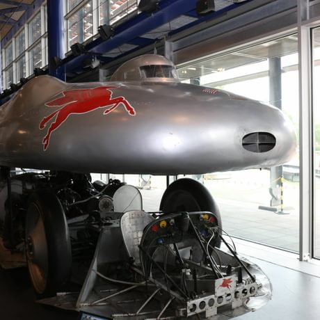 Futuristic looking silver car in a bullet type shape.