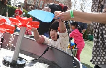 A children playing in a water feature in the Science Garden.