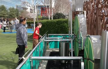 An adult and child using an interactive wheel in the Science Garden.