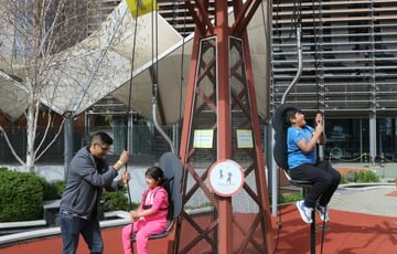 Children on an interactive pulley trying to pull themselves up.