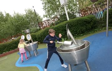 Two children playing with 2 water exhibits
