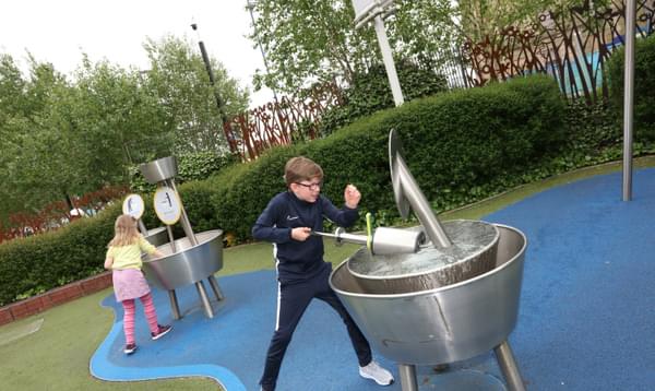 Two children playing with 2 water exhibits