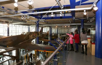 Family looking at a Spitfire plane suspended in the air.