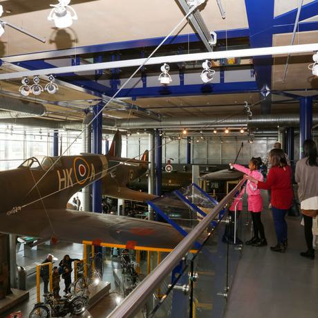 Family looking at a Spitfire plane suspended in the air.